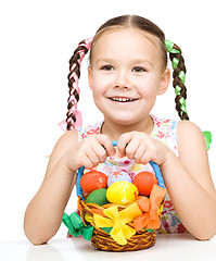 Image showing Little girl with basket full of colorful eggs