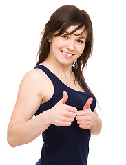 Image showing Woman is showing thumb up gesture