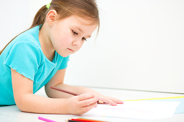 Image showing Little girl is drawing using pencils