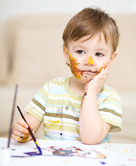 Image showing Little boy is playing with paints