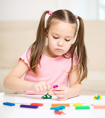 Image showing Little girl is playing with plasticine