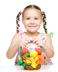 Image showing Little girl with basket full of colorful eggs