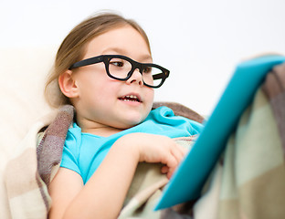 Image showing Little girl is reading a book