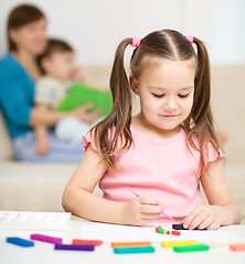 Image showing Little girl is playing with plasticine