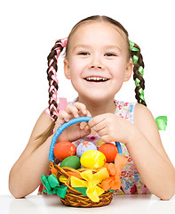 Image showing Little girl with basket full of colorful eggs