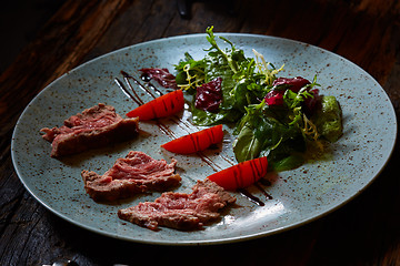 Image showing Grilled sliced roast beef and green salad