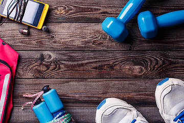 Image showing Sports equipment - sneakers, skipping rope, dumbbells, smartphone and headphones. 