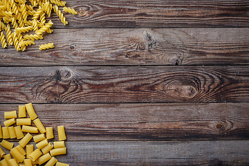 Image showing Mixed dried pasta selection on wooden background.