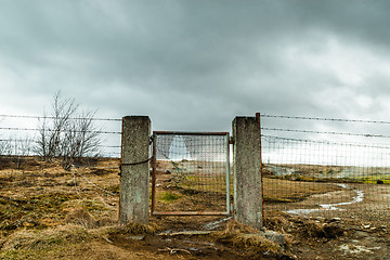 Image showing Broken gate on a field with barb wire