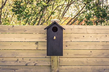 Image showing Black bird house on a fence