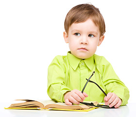 Image showing Little child play with book