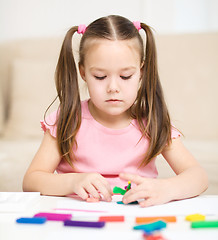 Image showing Little girl is playing with plasticine