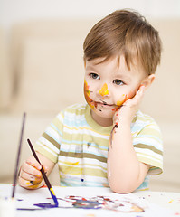 Image showing Little boy is playing with paints