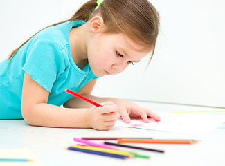 Image showing Little girl is drawing using pencils