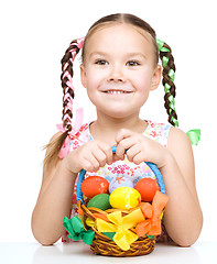 Image showing Little girl with basket full of colorful eggs