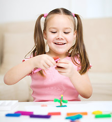 Image showing Little girl is playing with plasticine