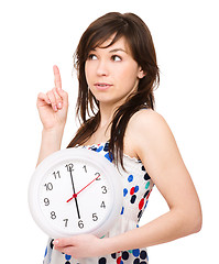 Image showing Young woman is holding big clock