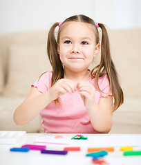 Image showing Little girl is playing with plasticine