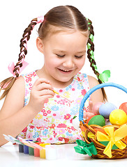 Image showing Little girl is painting eggs preparing for Easter