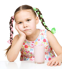 Image showing Gloomy little girl doesn\'t want to drink milk