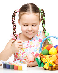 Image showing Little girl is painting eggs preparing for Easter