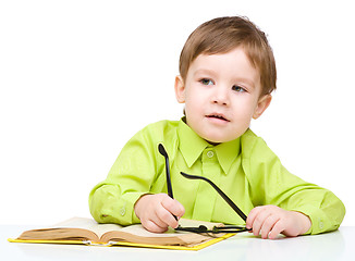 Image showing Little child play with book