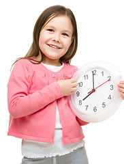 Image showing Little girl is holding big clock