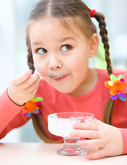 Image showing Little girl is eating ice-cream in parlor