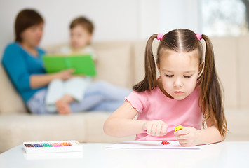 Image showing Little girl is playing with plasticine