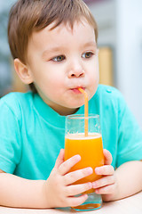 Image showing Little boy with glass of orange juice