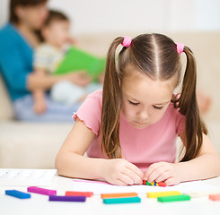 Image showing Little girl is playing with plasticine