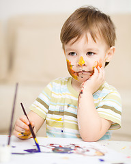 Image showing Little boy is playing with paints