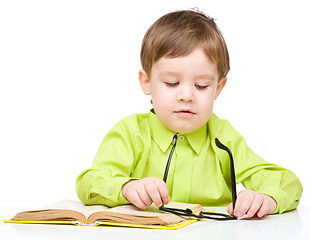 Image showing Little child play with book