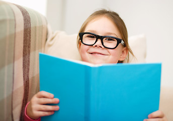 Image showing Little girl is reading a book