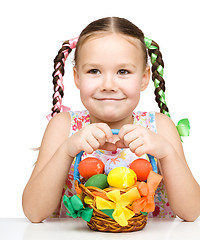 Image showing Little girl with basket full of colorful eggs