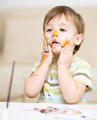 Image showing Little boy is playing with paints