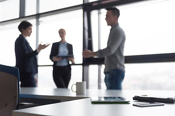 Image showing close up of tablet, business people on meeting in background