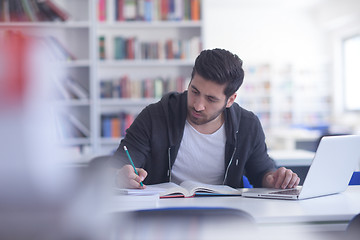 Image showing student in school library using laptop for research