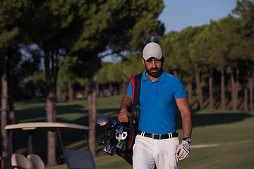 Image showing golfer  walking and carrying golf  bag