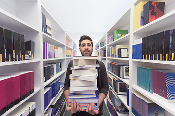 Image showing Student holding lot of books in school library