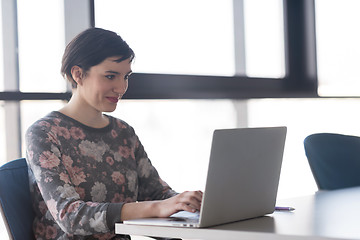 Image showing young business woman at office working on laptop with team on me