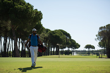 Image showing golf player walking and carrying bag