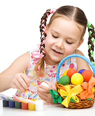 Image showing Little girl is painting eggs preparing for Easter