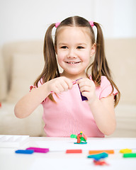 Image showing Little girl is playing with plasticine