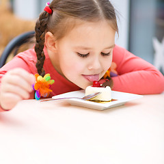 Image showing Little girl is eating cake in parlor