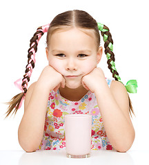 Image showing Sad little girl with a glass of milk