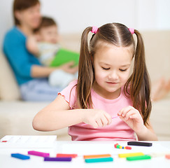 Image showing Little girl is playing with plasticine