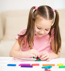 Image showing Little girl is playing with plasticine