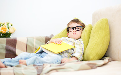 Image showing Little boy is reading book