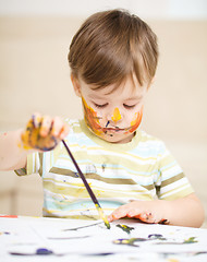 Image showing Little boy is playing with paints